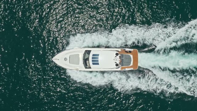 Yacht leaves marina and explores endless sea beneath warm sun. Luxury boat follows quietly. Motorboat creates gentle wake. Summer boating feels relaxing