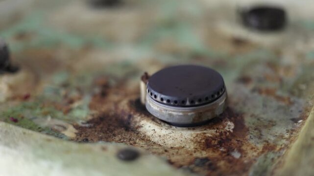Gas stove in grease. Cleaning the kitchen. Old gas stove. Grease on the enamel. Grease remover on the surface.
