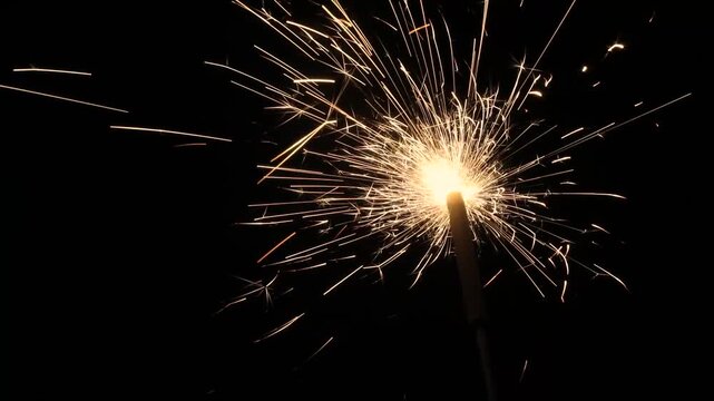 Sparks from a sparkler. Lots of sparks in the dark. Burning gunpowder on a black background.