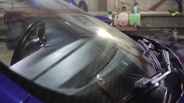 Wiping car glass. Car at the wash. Clean car. Car wash in the garage.