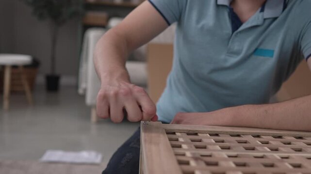 Man assembling wooden furniture with allen key