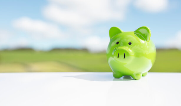 Green piggy bank against blue sky background savings, accounting, banking and business account or sustainable finance