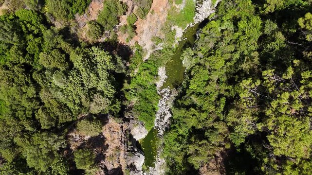 Aerial flyover tracking river upstream through gorge, Benahavis, Spain