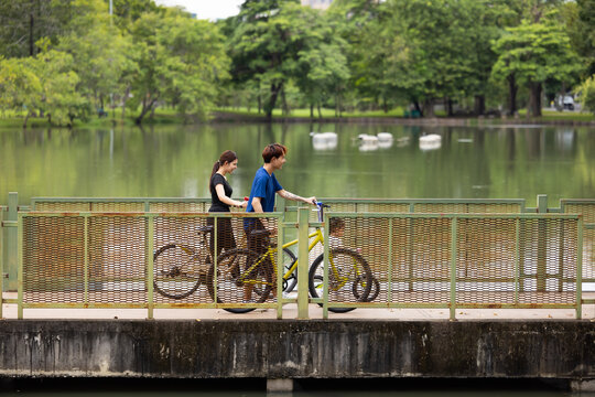 Happy Smiling father and mother with girl kid on bicycles having fun in city park. outdoor activitie with daughter father, mother and grandfather