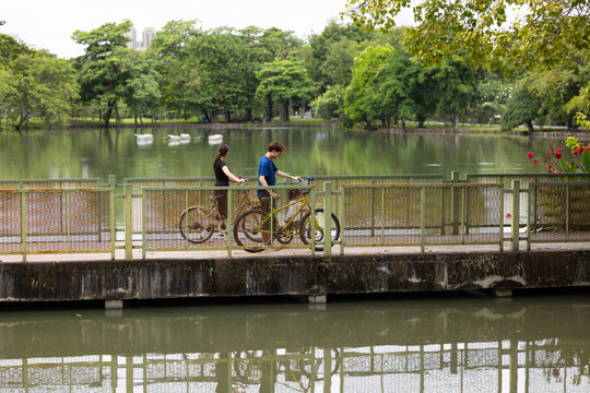 Happy Smiling father and mother with girl kid on bicycles having fun in city park. outdoor activitie with daughter father, mother and grandfather