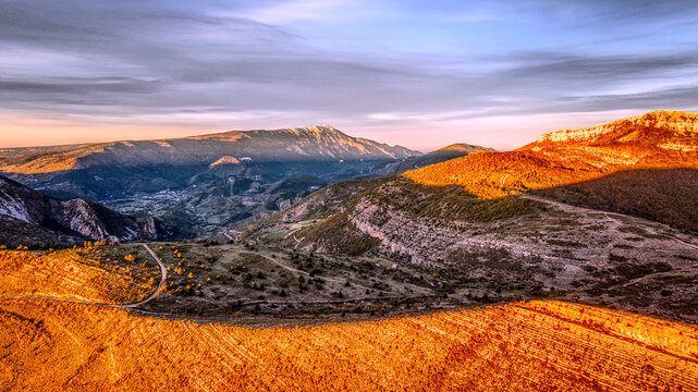 Golden Hour Panorama of Montagne de Buc, France
Stunning panoramic view of Montagne de Buc at sunset. Golden orange light bathes the rugged mountain slopes, creating a high contrast with deep shadows.