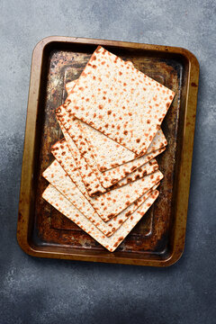 Matzoh jewish bread on a metal tray. Top view, on a gray background.