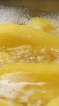 Cook potatos in boiling water in saucepan. Vertical footage