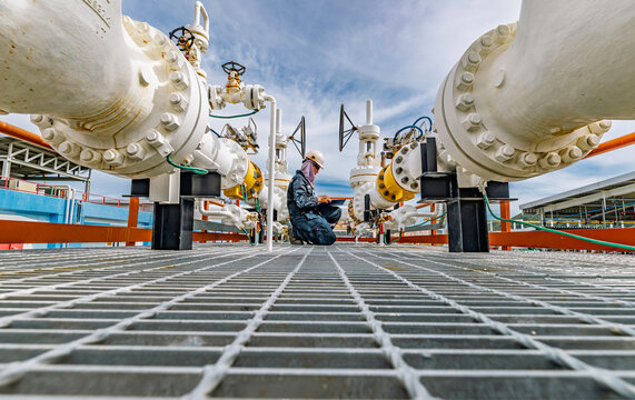 Male worker inspection at steel long pipes and pipe elbow in station oil factory during refinery valve of visual check record pipeline