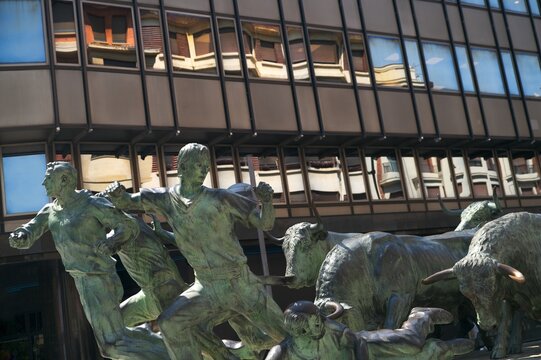 PAMPLONA, SPAIN - JULY 9, 2026: The famous Monumento al Encierro (Monument to the Running of the Bulls) bronze sculpture by Rafael Huerta on a city street during the San Fermin festival.
