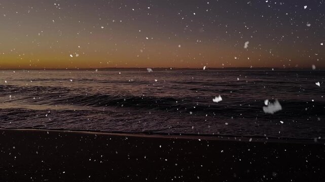 Snow falling over a calm sea at sunrise with gentle waves and golden morning light.