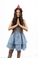Peaceful young girl wearing small crown holding hands in prayer in the studio
