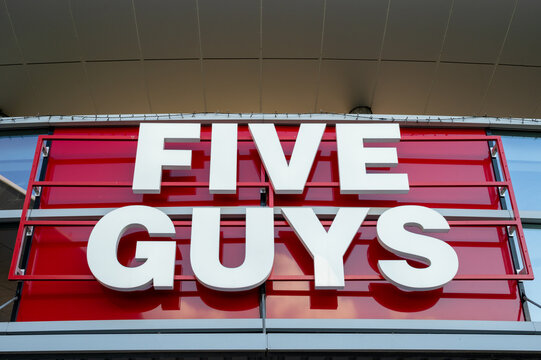 Wolfsburg, Germany - 13 July 2026: Five Guys burger restaurant exterior sign, modern red and white brand logo on a building facade at Designer Outlets Wolfsburg