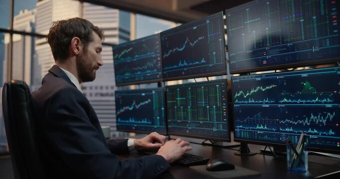 Stock Exchange Broker Analyzes Market Data on a screens atTrading Desk, Price Charts, Financial Analytics, and Capital Growth as He Executes Investment Strategies in Office