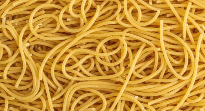 A tangle of uncooked spaghetti noodles dominates the image. The strands are a vibrant yellow color and are densely packed together, creating a chaotic and textured surface.