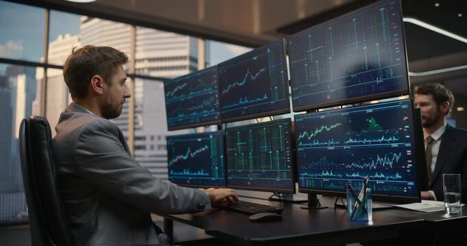 Two Male Financial Analysts  Work at Desks With monitors with Trading Setup, Analysing Equity Charts and Market Analytics to Manage Investment Portfolios and Capital Returns. Asset management Company