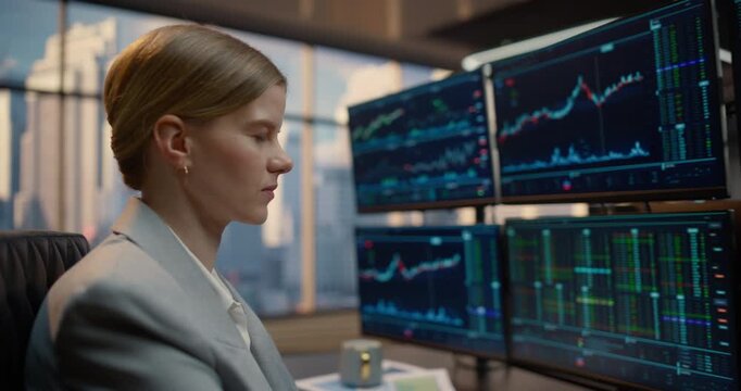 Portrait of Professional Woman Broker Monitors Stock Exchange Markets Across Computer Screens at a Trading Desk, Examining Equity Graphs, Financial Analytics and Ticker Data to Grow Investment Capital