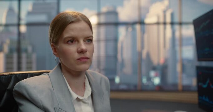 Portrait of Confident Young Caucasian Businesswoman Sits Focused in a Modern Office. Businesswoman Career, Leadership. Successful Female Executive Preparing for Corporate Meeting and Negotiations