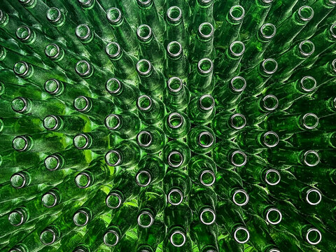 Abstract background of green glass bottles. Concept of glass recycling, reusable bottles, circular economy, bottle deposit return system (Pfand) and sustainable waste management.