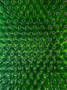 Abstract background of green glass bottles. Concept of glass recycling, reusable bottles, circular economy, bottle deposit return system (Pfand) and sustainable waste management.