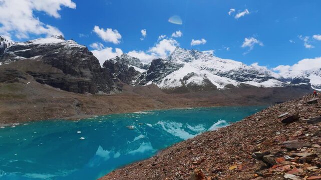 4K shot of blue colored Ghepan Ghat Lake besides the snowy Himalayan mountain peaks during the summer season near Sissu village in Lahaul and Spiti district, Himachal Pradesh, India. Nature background