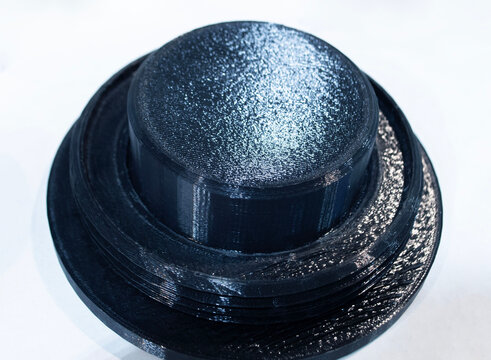3D printed part from black plastic on 3D printer. Object printed on 3D printer from molten plastic isolated on white background. FDM Fused Deposition Modeling technology. Additive modern manufacturing
