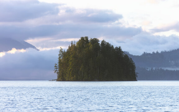 Fjord landscape at dusk with cloudy sky over mountains