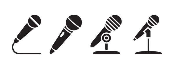 Four black microphone icons with stands and cables for audio recording on transparent background. © Kamil