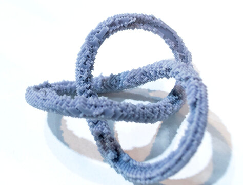 3D printed model of infinity loop. Voxel art style. Model created using photopolymer resin. Object printed on 3D printer from liquid resin isolated on white background SLA technology Stereolithography