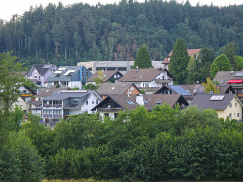 germany, peaceful elzach village homes framed by lush green trees beneath colorful glowing sunset in spectacular black forest summer scenery