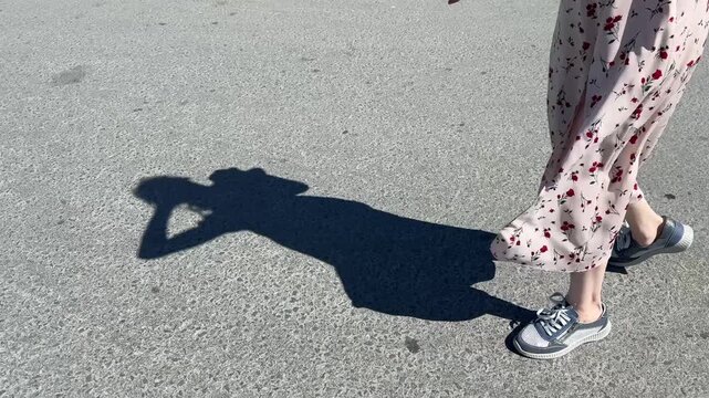A Caucasian woman with mild cerebral palsy walks down the street. Close-up of legs.