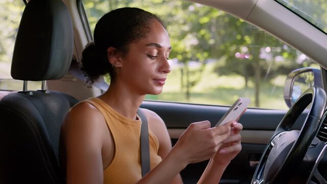 Bored tired African American business woman using mobile phone inside car fatigued female browsing smartphone in vehicle dissatisfied online content transportation entrepreneur traveler girl apathy