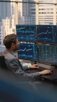 Vertical Screen. Portrait of  Male Broker Studies Fluctuating Stock Market Graphs and Financial Analytics at Office Desk, Executing Trades and Evaluating Investment Opportunities for Wealth Building.