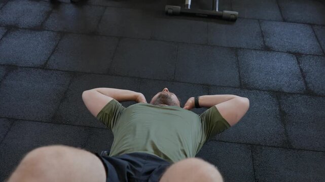 Man training core doing sit ups in gym