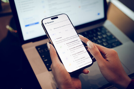 Businesswoman using AI search interface on a transparent virtual search bar above a laptop, representing artificial intelligence, smart search, and digital technology.
