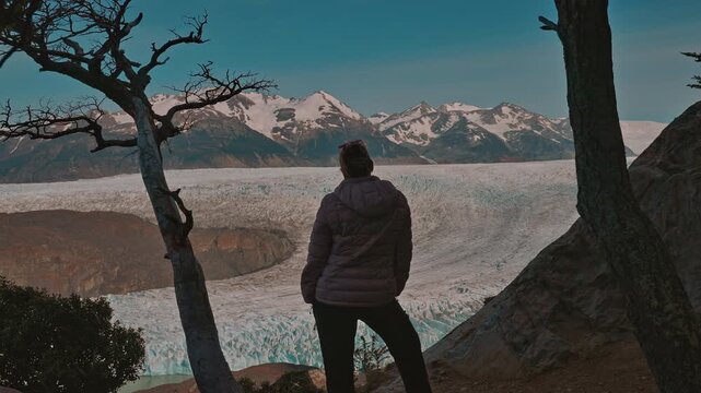 Rear view of woman looking out at the majestic Grey Glacier on a sunny day, Torres de Paine, Patagonia Chile