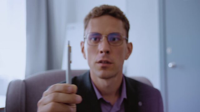 Male therapist in glasses using a pen for an emdr session, guiding a patient's eye movements