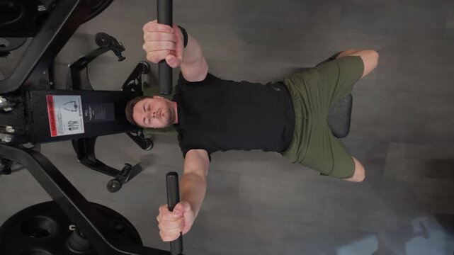 Man training chest press machine in gym