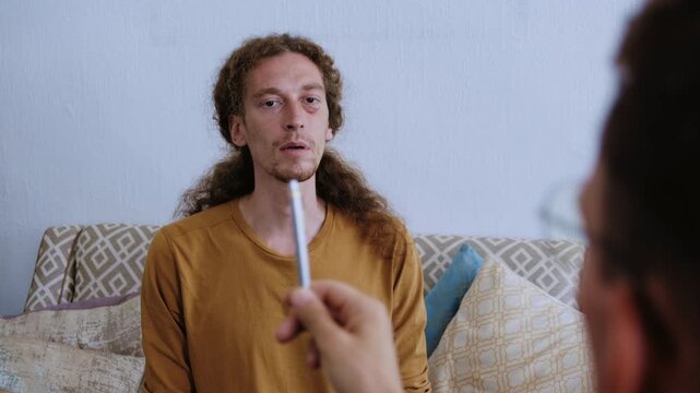 Professional hypnotherapist using a pen for eye movement desensitization with a male patient