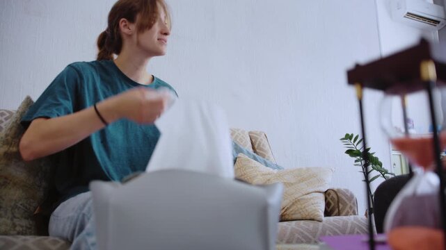 Distressed patient pulling a tissue from a box while talking with a psychologist in the office