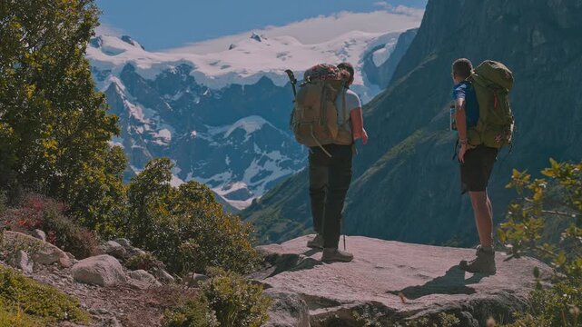Trekking couple taking in the beautiful mountainous landscape of Torres del Paine on a sunny day, Patagonia, Chile