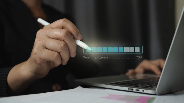 Professional businesswoman using a digital stylus pen to manage work in progress updates on a laptop computer with a virtual progress bar interface