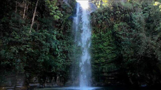 Cinematic slow motion close up of moody waterfall in dark tropical forest