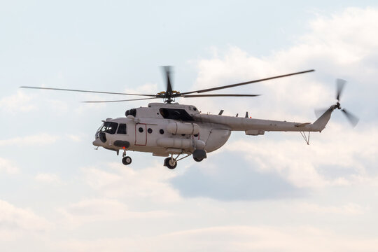 A white multi-purpose helicopter flies in the sky