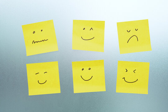 notepad and smiley faces. different post-its of various colors with representing diversity and inclusion.