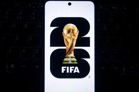 Pacitan, Indonesia - July 14, 2026 : Close-up of the FIFA World Cup 2026 emblem displayed on a smartphone screen over a keyboard.
