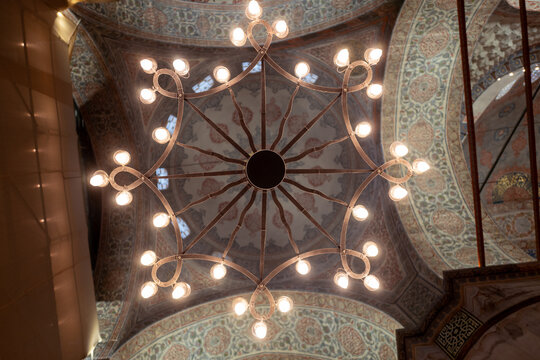Blue Mosque's Heart: A Glowing Chandelier in a Sea of Iznik Tiles.
