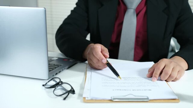 Young businessman working at desk. document check concept with a businessman open a document sheet and using pen to write and checking
