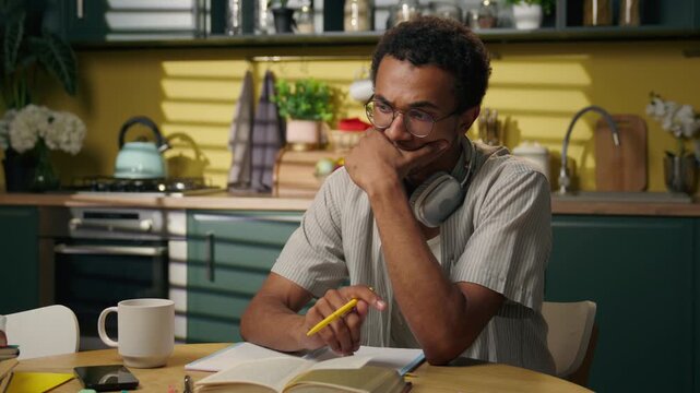 Sad thoughtful African American man thinking at home kitchen about difficult problem male student freelancer pondering trouble searching for solution doubtful brainstorming homework ideas alone indoor