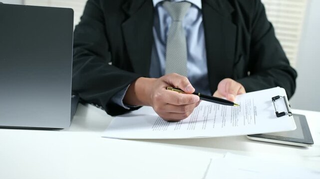 Manager or businessman explains documents to prospective employees or clients and then hands them the documents to be signed.